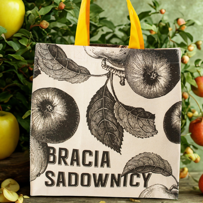 Custom tote bag for Bracia Sadownicy featuring an apple print on natural cotton and sunny yellow handles.